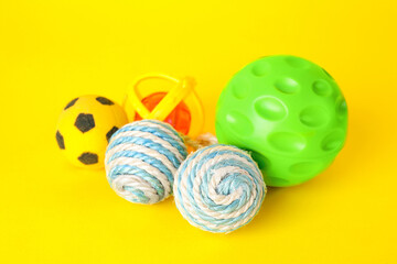 Various bright pet toys on yellow background