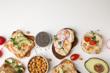 Delicious sandwiches with hummus and different ingredients on white background, flat lay. Space for text
