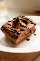 sponge cake with whole pear and chocolate on a white plate