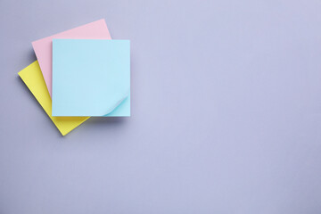 Paper notes on light purple background, top view. Space for text