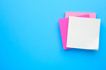 Paper notes on light blue background, top view. Space for text