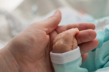 mom holds a baby's pen on a blurry background