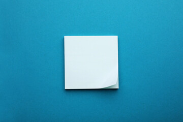 Paper note on blue background, top view