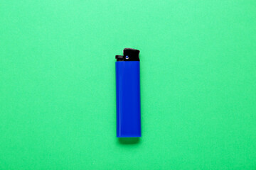 Stylish small pocket lighter on green background, top view