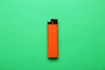 Stylish small pocket lighter on green background, top view