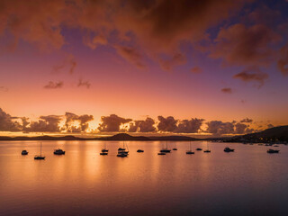 Fototapeta premium Aerial sunrise waterscape with boats, clouds and reflections