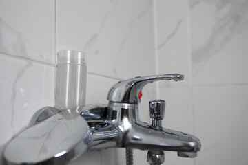Bottles of shower gel on faucet in bathroom. Space for text