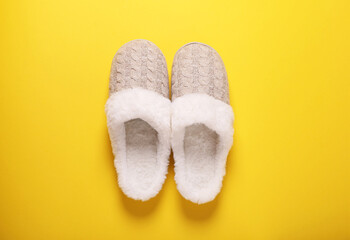 Pair of beautiful soft slippers on yellow background, top view