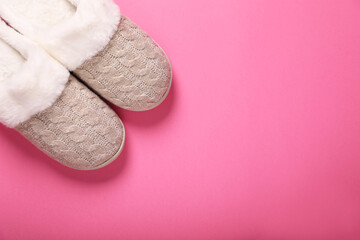 Pair of beautiful soft slippers on pink background, top view. Space for text