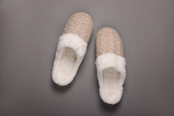 Pair of beautiful soft slippers on grey background, top view