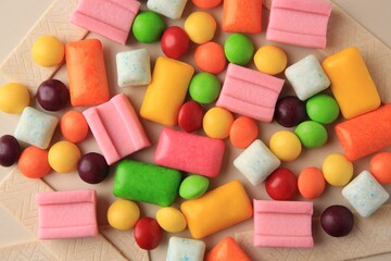 Many different chewing gums on beige background, flat lay
