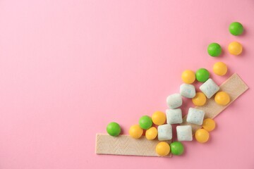 Different tasty chewing gums on pink background, flat lay. Space for text