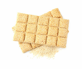 Tasty sweet kozinaki bars and sesame seeds on white background, top view