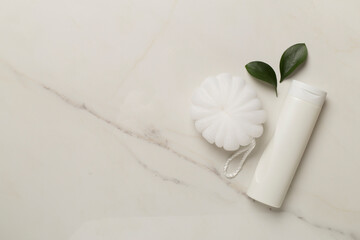 Shower gel with washcloth on marble background, top view