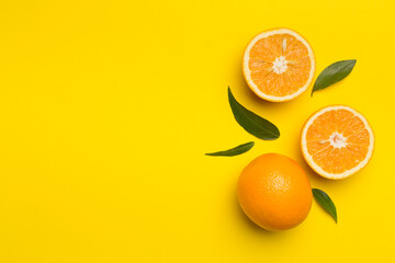 Flat lay with fresh oranges and leaves on color background