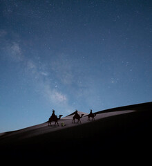 Los reyes magos del Oriente, en sus camellos, en el desierto, guiados por la estrella polar.	