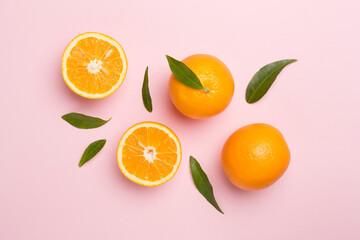 Flat lay with fresh oranges and leaves on color background