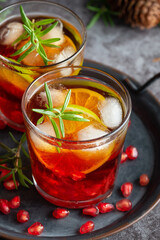 Pomegranate cocktail decorated with lime, rosemary and Ice, cold drink