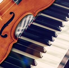 Violin on top of piano keyboard background for music concept