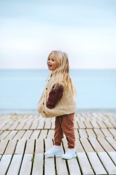 Child girl happy smiling walking outdoor kid wearing fluffy sherpa jacket fashion outfit 4 years old blonde hair