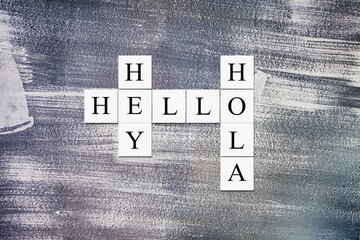 Hey Hola Hello letters, tiles against abstract background. © BillionPhotos.com