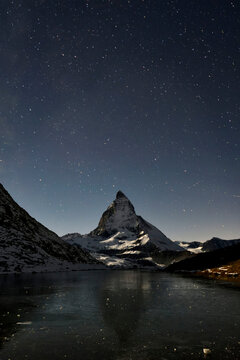 The Matterhorn looms above a frozen lake.; Gornergrat, Zermatt, Switzerland.