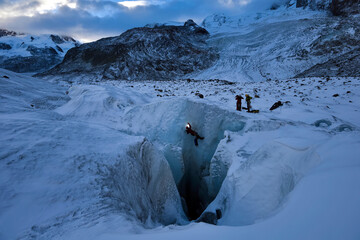 A cave explorer descending into the None Stop moulin on Gorner Glacier.