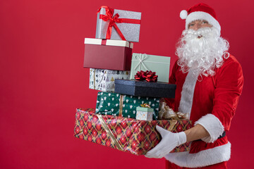 Portrait von einem verkleideten Weihnachtsmann mit Geschenk, isoliert auf roten Hintergrund im Studio im Querformat