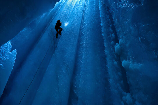A cave explorer in the main entrance shaft of the None Stop moulin on the Gorner Glacier.