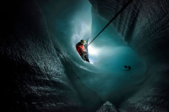 A cave explorer descends down the narrow passages of Gorner Glacier.
