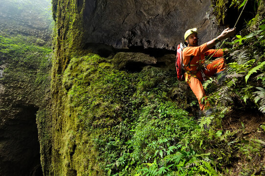 A cave explorer climbs a thin rope in the Er Wang Dong cave system.