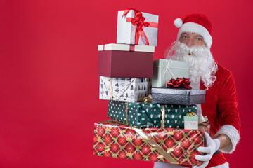 Portrait von einem verkleideten Weihnachtsmann mit Geschenk, isoliert auf roten Hintergrund im Studio im Querformat