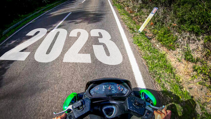 Scooter riding on a country road with 2023 written on it