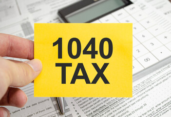 yellow paper with the words 1040 tax and tax forms with calculator
