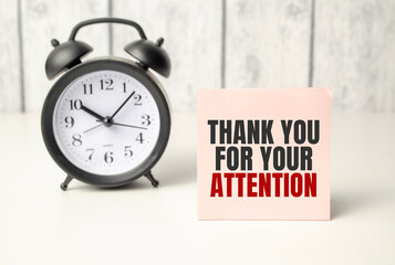 The words Thank Your For Your Attention on alarm clock and wooden background