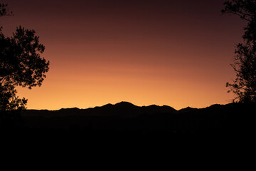 Silhouette of the Andes mountain range in a deep orange sunset. View from Lujan de Cuyo in Mendoza.