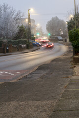 Motion blur lights on cars queuing up a hill on a frosty winter evening