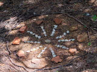 Ornamente und Kreise aus kleinen Schneckenhäuser und Steinen