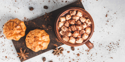 Hot chocolate drink with marshmallows in a cup and sweet bakery eclair dessert sprinkled with cocoa...