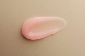 Sample of cosmetic gel on beige background, top view