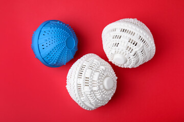 Dryer balls for washing machine on red background, flat lay