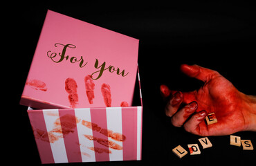 gift box with blood prints and a hand covered in blood