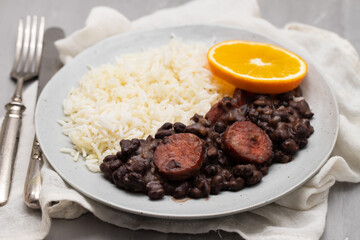 Typical brazilian food beans with sausages and rice Feijoada on white dish