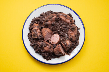 black beans stew with sausages on a white dish