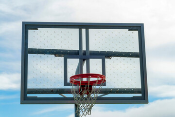Skylined basketball hoop with clear ventilated backboard and traditional orange rim with white net...