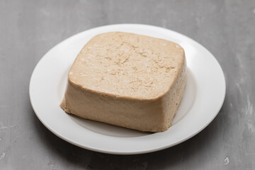 raw tofu block on white small dish on ceramic
