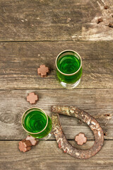 St. Patrick's Day concept. Traditional green cocktail, sweet chocolate in the shape of clover leaves