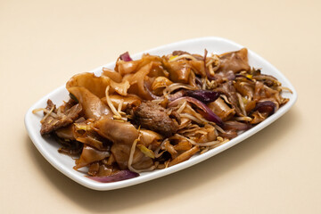 Fried noodles with vegetables and beef in white dish