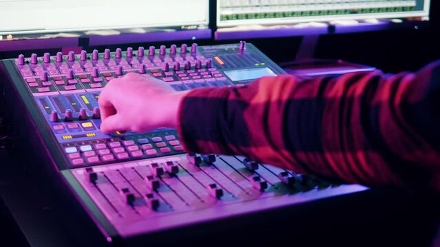 Mixing console is operated by a sound producer at audio recording studio
