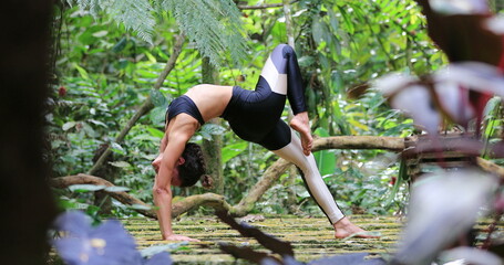 Fit Yogi woman training Yoga bridge pose outdoors